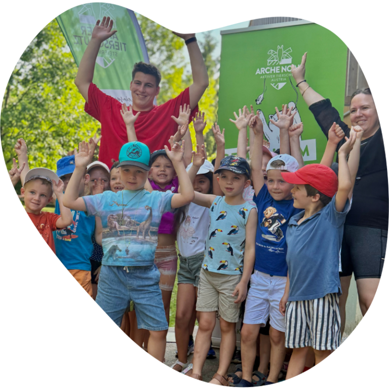 Benefizlauf MS Ursulinen Graz für die Arche Noah - Aktiver Tierschutz Austria Gruppe von Kindern und Erwachsenen feiert, mit erhobenen Händen und lächelnden Gesichtern.